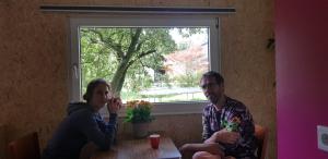 a man and a woman sitting at a table at Huisje de Bosrand in Bant