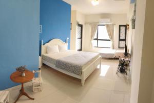 a bedroom with a bed and a blue wall at 稼鄉旅宿 in Xizhou