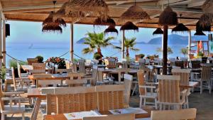 ein Restaurant am Strand mit Tischen und Stühlen in der Unterkunft Villa Nickolas in Palaió Tsiflíki