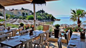 ein Restaurant mit Tischen und Stühlen und Meerblick in der Unterkunft Villa Nickolas in Palaió Tsiflíki