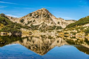 a mountain reflecting in a lake in the mountains at Villa Raphael w Jacuzzi near Pirin Golf Resort in Bansko