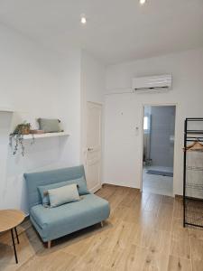 a living room with a blue couch and a table at La Casa Delviga in Olivella