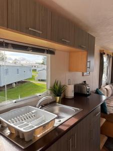 a kitchen with a sink and a large window at Static home sleeps 6 in Dawlish Warren