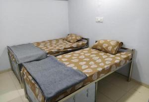two twin beds in a room with at Sainik Dormitory and Room Service in Lucknow