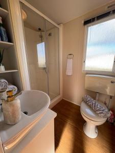 a bathroom with a white sink and a toilet at Static home sleeps 6 in Dawlish Warren