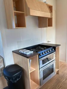 a kitchen with a stove and a trash can at Static home sleeps 6 in Dawlish Warren +7 photos