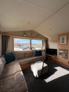a living room with a couch and a large window at Static home sleeps 6 in Dawlish Warren
