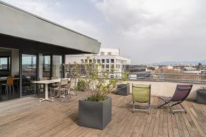 a balcony with chairs and a table on a building at The Originals Residence Appart Hôtel Hévéa Valence in Valence