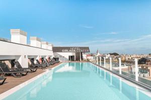 a large swimming pool on the roof of a building at Hotel Giralda Center in Seville