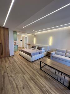 a bedroom with a bed and a couch and a table at Villa Xika in Sarandë