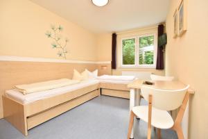a room with two beds and a desk and a window at Villa Ephraim in Görlitz
