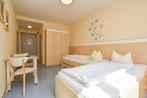 a bedroom with two beds and a desk and a chair at Villa Ephraim in Görlitz