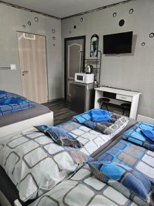 two beds in a room with a tv on the wall at Kids' Paradise House in Balatonboglár +16 photos