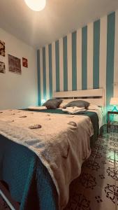 a bedroom with a large bed with a striped wall at Labottega home in Lipari