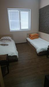 two beds in a room with a window at стаи за настаняване in Razgrad