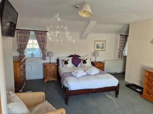 a bedroom with a bed and a couch and a tv at Wheelgate in Torver