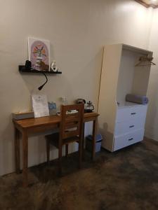 ein Schreibtisch mit Stuhl und Schrank in einem Zimmer in der Unterkunft Bitang's Guesthouse - Starlink Ready in Burgos + 12 Fotos