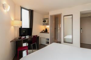 a hotel room with a bed and a desk at The Originals Residence Appart Hôtel Hévéa Valence in Valence