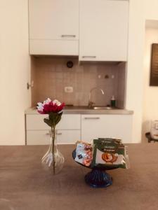 a table with a vase of flowers and a book at Labottega home in Lipari