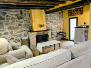 a living room with couches and a stone fireplace at Navas de Lema in Las Navas de Buitrago