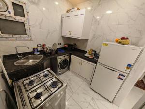 a small kitchen with a sink and a refrigerator at Red Sea Downtown in Hurghada