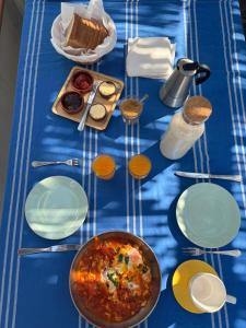 a blue table with plates of food on it at Suite no campo in Cercal