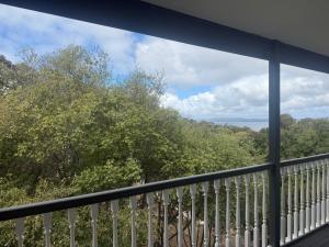 a balcony with a view of trees and water at Pillais B and B in Albany