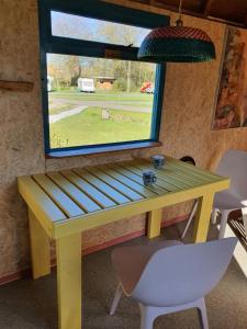 a yellow table and a window in a room at De Maanloper in Bant