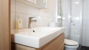 a white bathroom with a sink and a toilet at Forenom Hostel Gothenburg Säve in Gothenburg +11 photos
