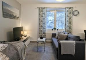 a living room with a couch and a window at Forenom Hostel Gothenburg Säve in Gothenburg