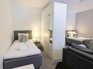 a small bedroom with two beds and a couch at Forenom Hostel Gothenburg Säve in Gothenburg