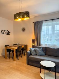 a living room with a couch and a table at Apartmán U Čápů Mladé Buky 59 in Mladé Buky