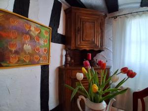 a vase of tulips in a room with a painting at Ferien im Kellisch-Haus in Schalkenmehren +44 photos