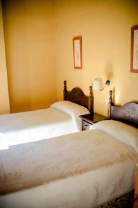 a bedroom with two beds and a table with a lamp at Casa del Huerto in El Bosque