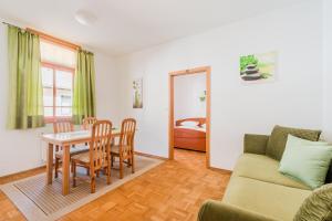 a living room with a couch and a table and chairs at Apartments Rombon Klavdij with Free Onsite Parking in Bovec