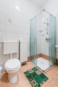 a bathroom with a toilet and a glass shower at Apartments Rombon Klavdij with Free Onsite Parking in Bovec +34 photos