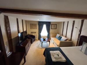 a room with a bed and a couch and a television at Sams Wine Bar Harwich ltd in Harwich