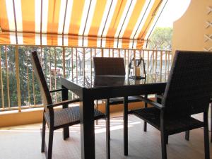 a black table and chairs on a balcony at Appartement Marco Polo in Mandelieu-La Napoule