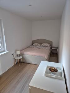 a small bedroom with a bed and a table at Green River Apartment in Stahovica
