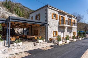 a stone building with chairs and tables in front of it at Casarogna Luxury Rooms in Cetinje