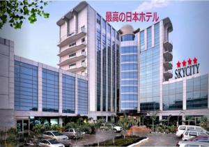 a large building with cars parked in a parking lot at SkyCity Hotel Gurgaon in Gurgaon