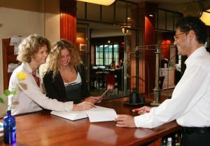 a man and a woman standing at a bar with a man at Romantik Hotel Kaufmannshof in Bergen auf Rügen