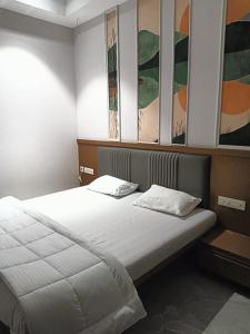 a bedroom with two beds and paintings on the wall at LL Palace in Hinganghāt
