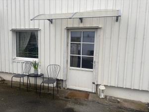 two chairs in front of a building with a door at Studio Ranch Johanna in Kullavik