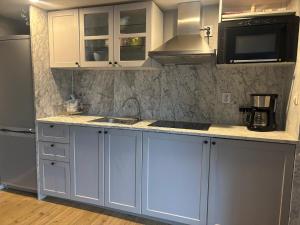 a kitchen with white cabinets and a sink at Studio Ranch Johanna in Kullavik