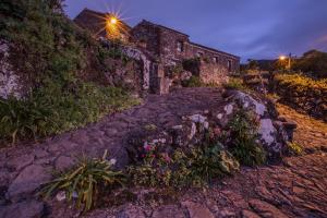 a stone path leading up to a building with flowers at Aldeia da Cuada in Faja Grande