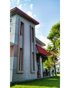 a building with a red roof and green grass at Ikegami Dapo Moutain Bed and Breakfast in Chishang