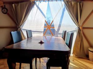 a dining room table with chairs and a large window at Mush's rooms in Saint-Julien-Labrousse +32 photos