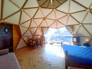a room with a bed and a table in a yurt at Mush's rooms in Saint-Julien-Labrousse
