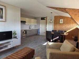 a living room with a couch a table and a kitchen at Molesicht en Lânsicht in Workum